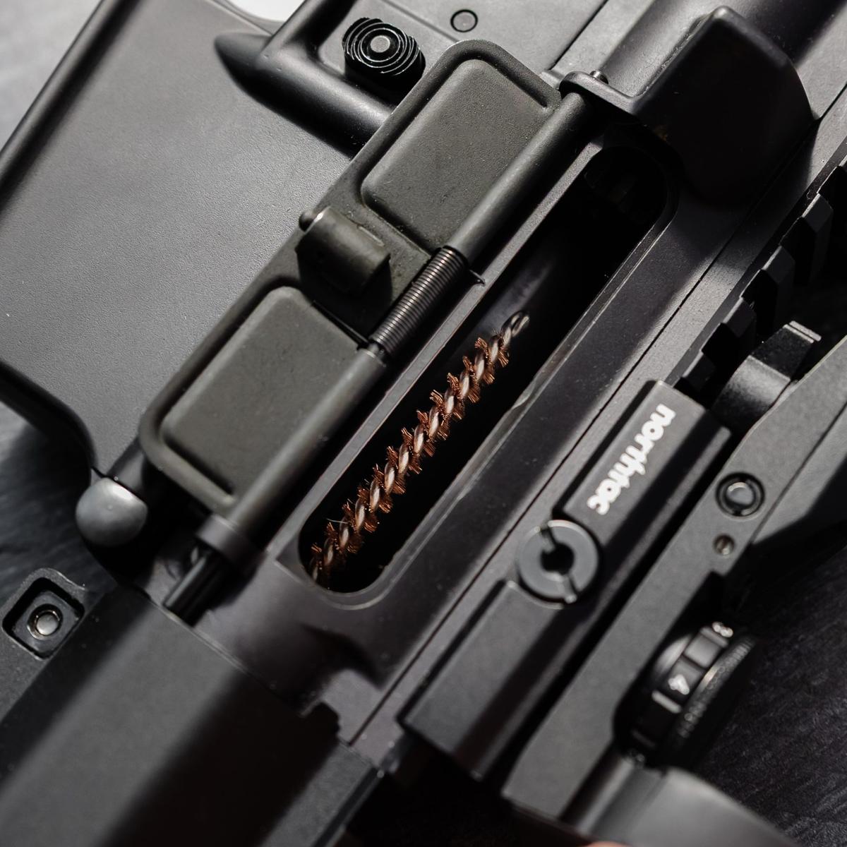 Copper brush seen through a rifle receiver